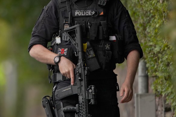 An armed police officer patrols near the scene of a stabbing incident.