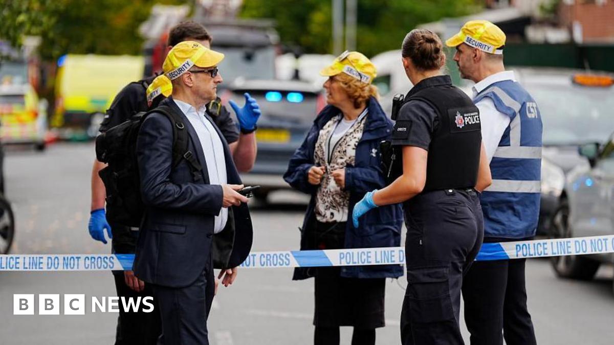 Members of the Community Security Trust (CST) speak to a police officer at the cordon near the scene of an incident at Heaton Park Hebrew Congregation synagogue in Crumpsall, Manchester