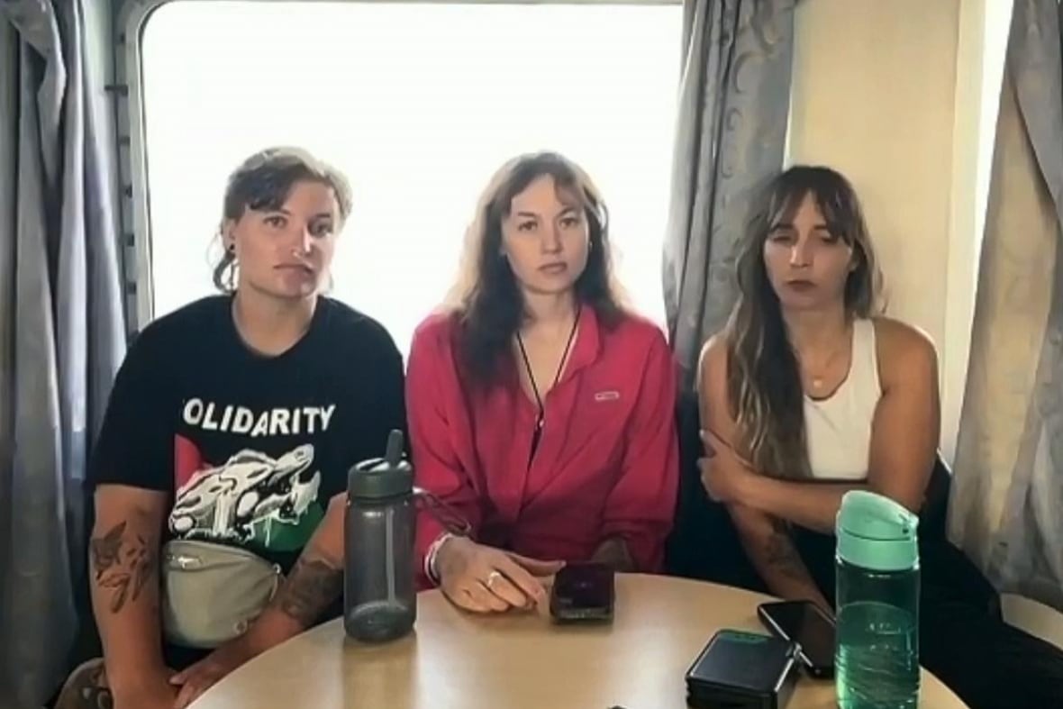Three people sitting at a rounded table.