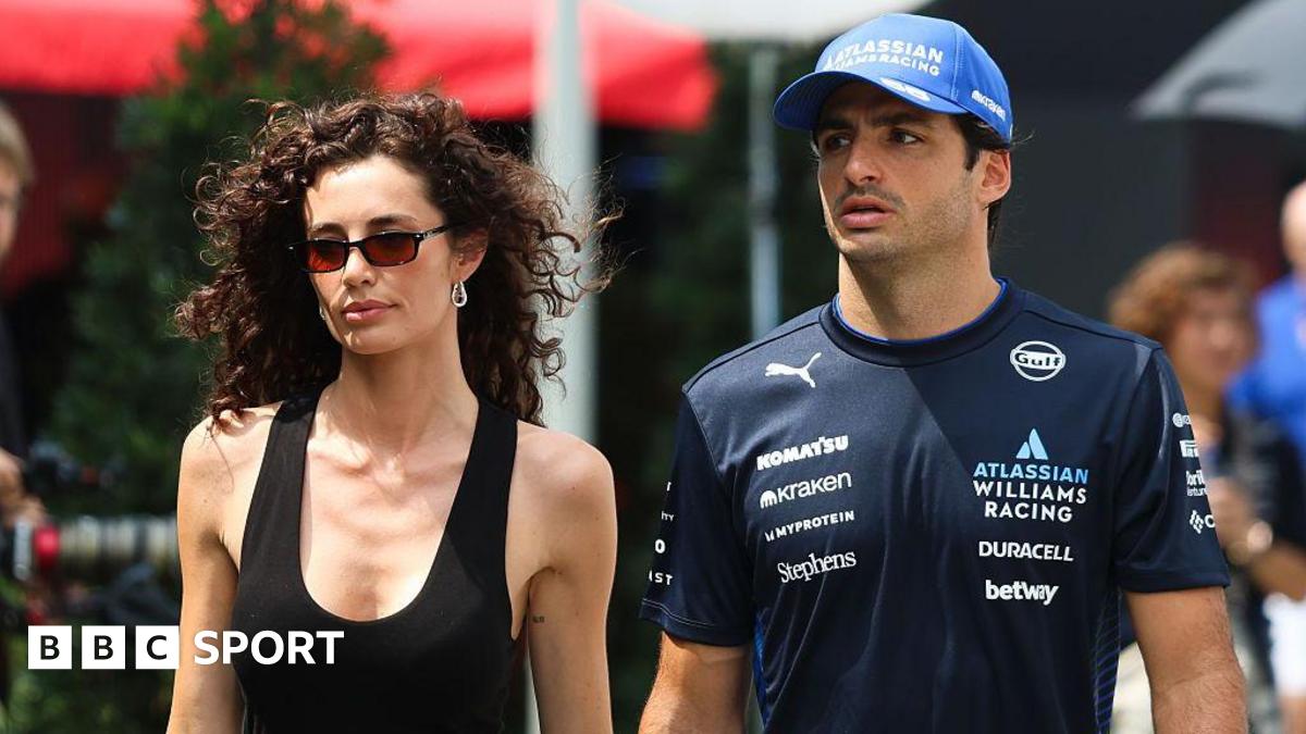 Rebecca Donaldson and Carlos Sainz walk into the paddock in Singapore