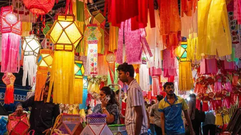 Getty Images People shop for lanterns displayed at roadside stalls in Mumbai on October 14, 2025, ahead of 'Diwali', the Hindu festival of lights.