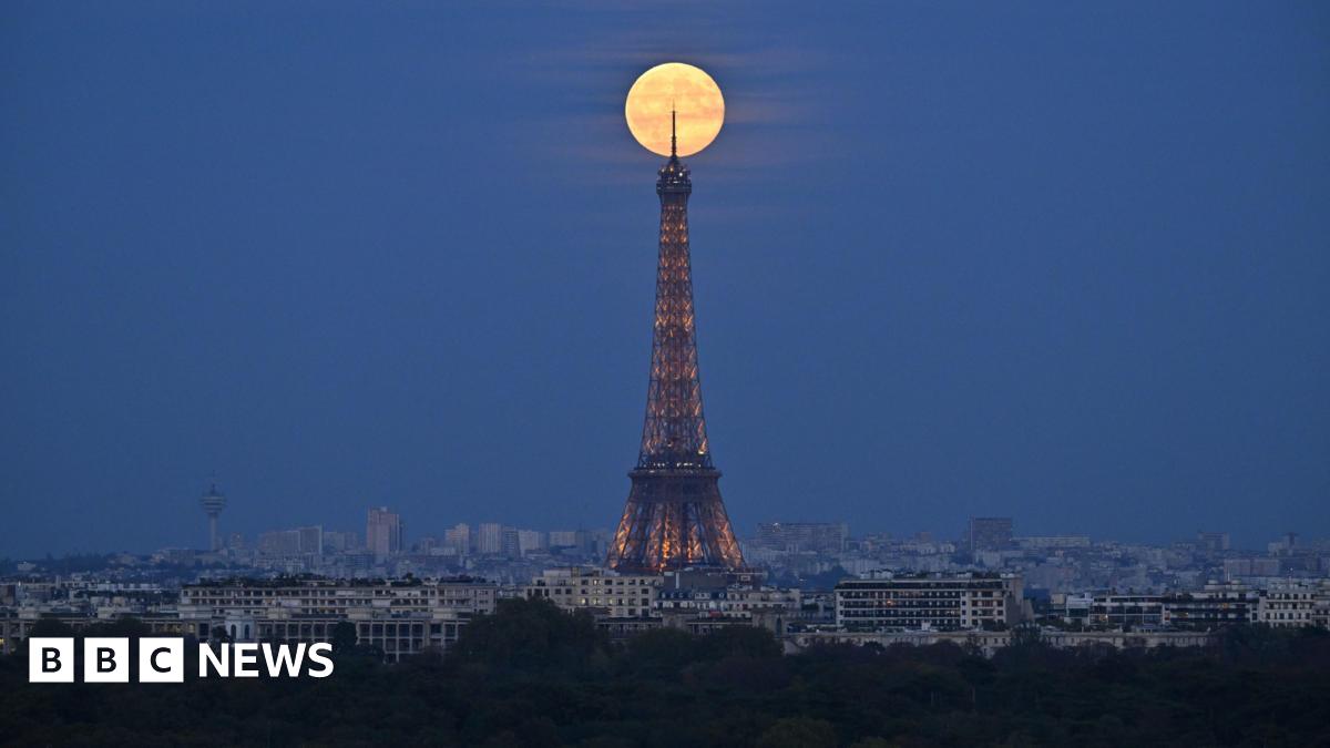 The bright supermoon sitting at the tip of the Eiffel Tower in Paris