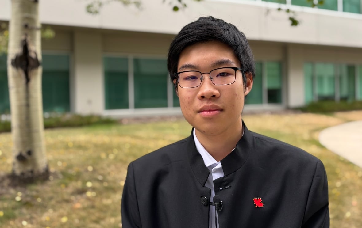 A teenager looks at the camera with a straight face.