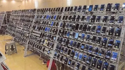 US District Court EDNY A room full of racks that carry hundreds of mobile phones, each plugged into a power source.