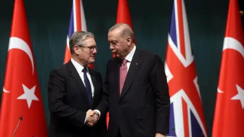 EPA Sir Keir Starmer and Turkish President Recep Tayyip Erdogan shake hands in front of the UK and Turkish flags 