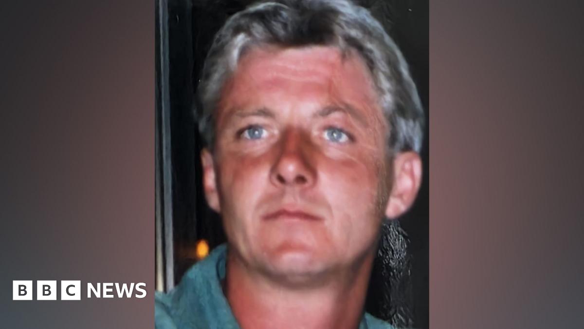 A photo of a man with short, silver hair and blue eyes. He is looking towards, but not directly at, the camera.