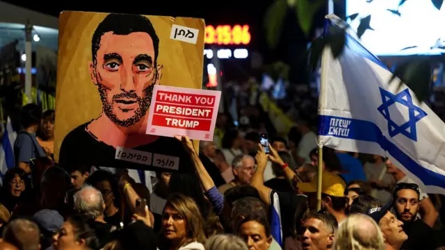 A demonstrator holds a placard with a message thanking U.S. President Donald Trump, as people gather in "Hostages square"