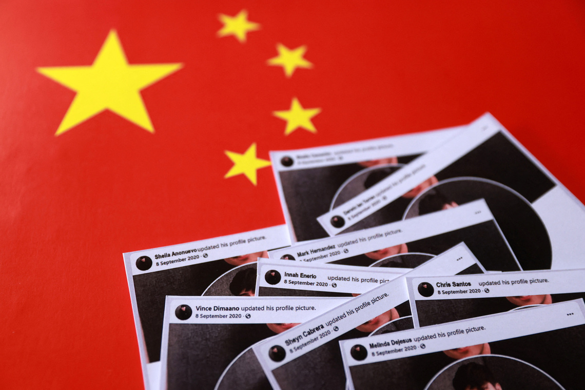 Paper cut-outs of posts from fake Facebook profiles are placed on a Chinese flag in this illustration taken October 3, 2025. REUTERS/Dado Ruvic/Illustration