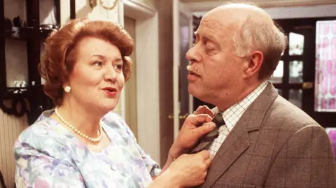 Dame Patricia as Hyacinth Bucket with Clive Swift as long-suffering husband Richard in Keeping Up Appearances