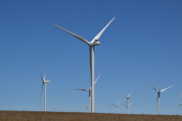 A large white wind turbine in an open field.