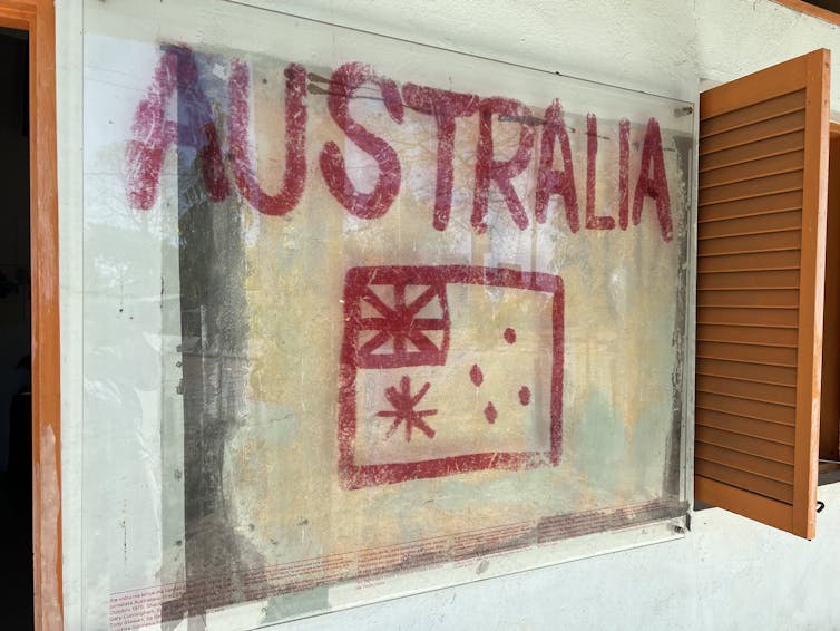 A concrete building with the word Australia and its flagged painted in red