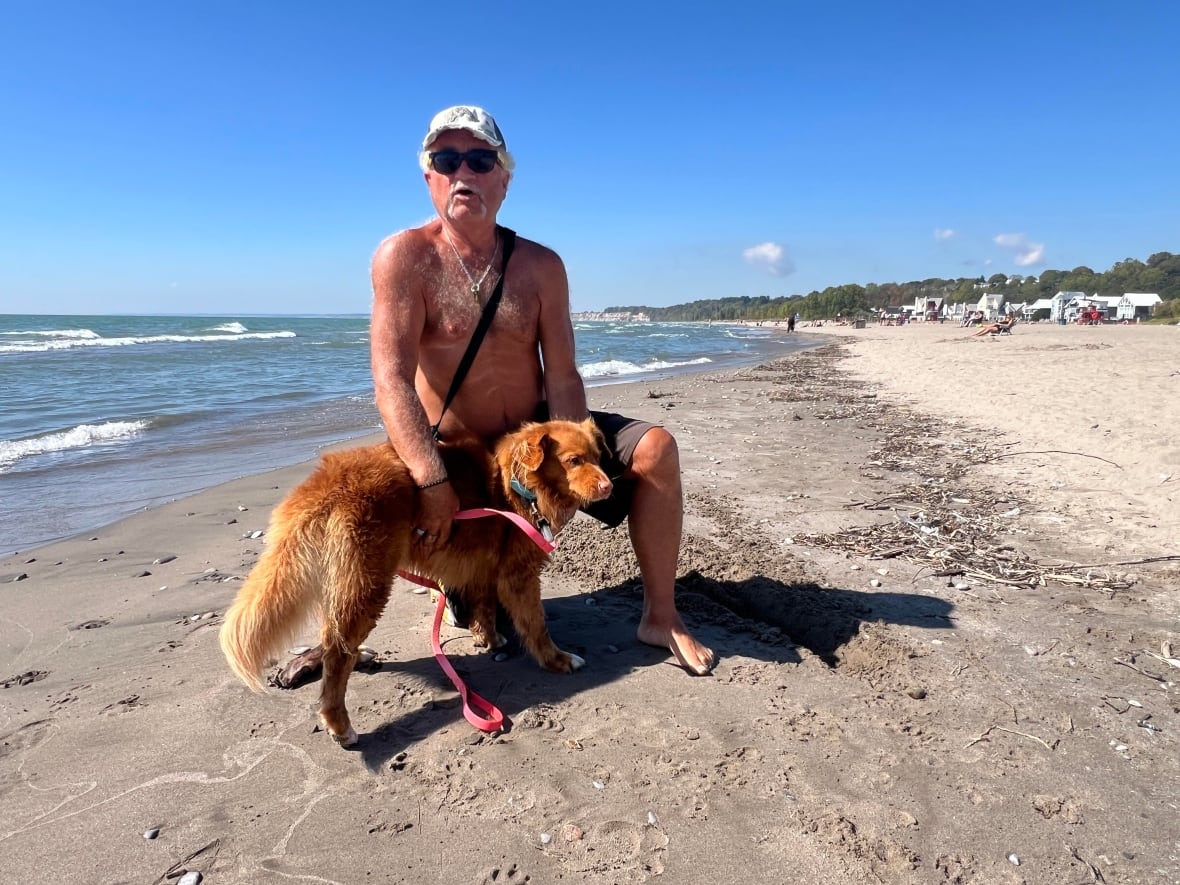 Shirtless in the summer-like sun, Gary Curtis and his dog Muddy took a stroll on Port Stanley Beach on Friday. 