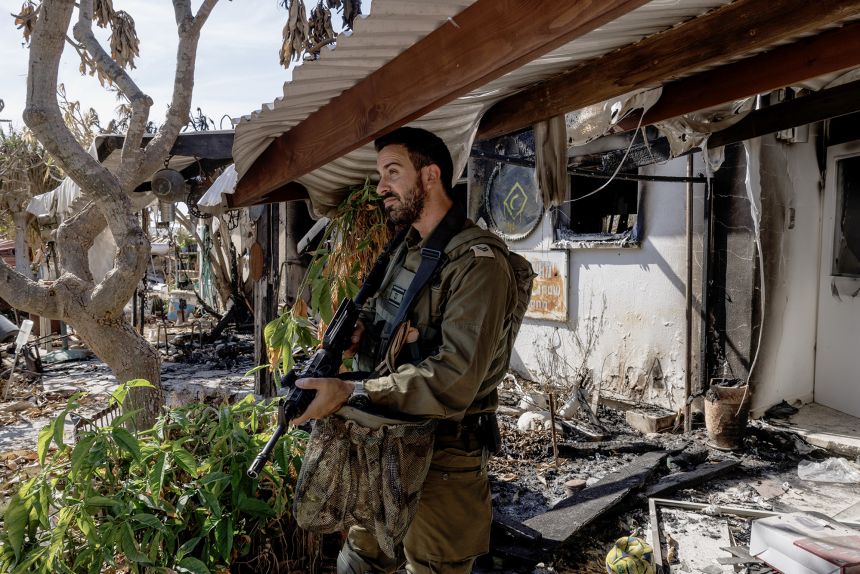 A soldier inspects a burnt out home at kibbutz Nir Oz on October 30, 2023.