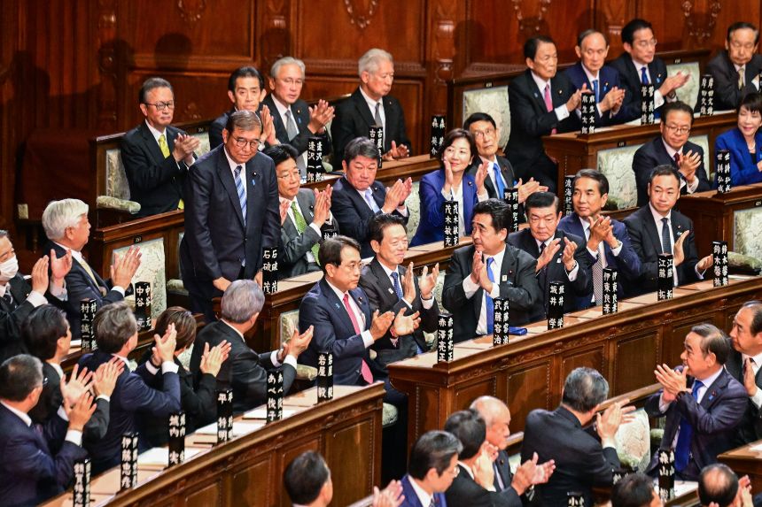 Lawmakers applaud as Japan's Prime Minister Shigeru Ishiba (standing to the left) is reappointed as leader during a special parliament session in Tokyo on November 11, 2024.