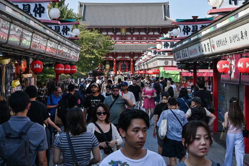 Crowds of visitors walk past shops in front of Sensoji Temple, a major tourist attraction in central Tokyo, on September 16, 2025.