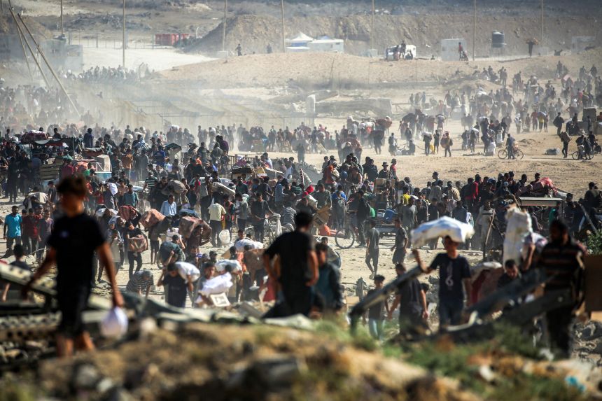 People walk with humanitarian aid packages that they received from a distribution centre in the central Gaza Strip, on Tuesday.