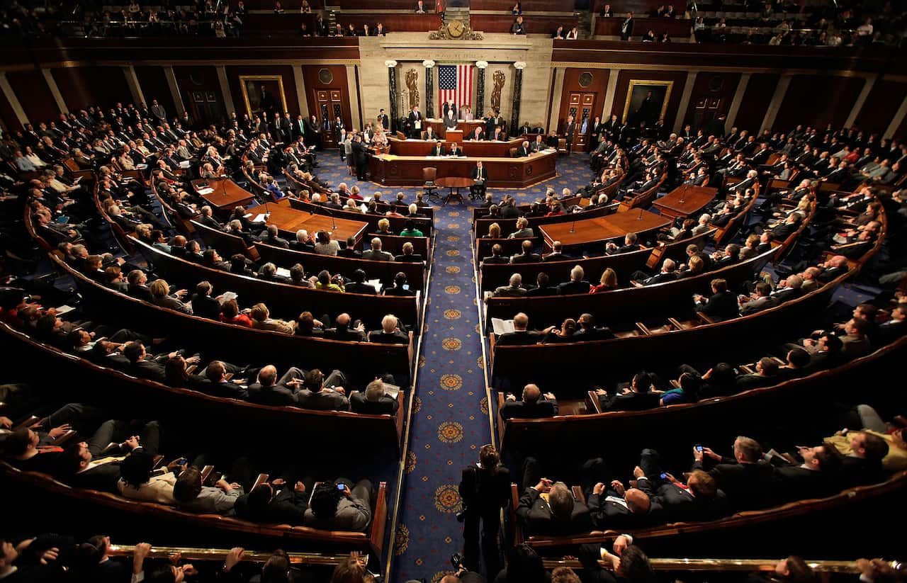 A joint session of the US Congress meets in the House chamber with leaders sitting in semi-circular rows.