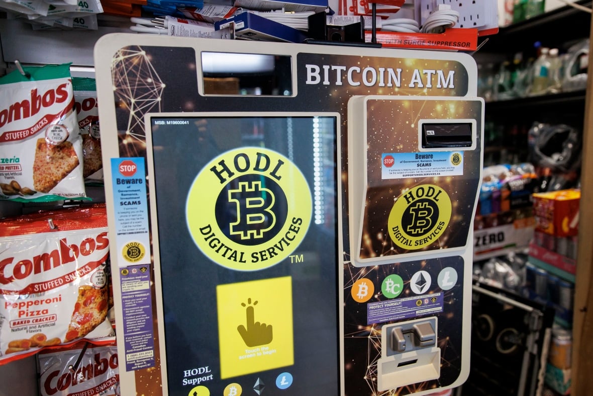 A Cryptocurrency ATM and accompanying romance scam warning is pictured in a convenience store.