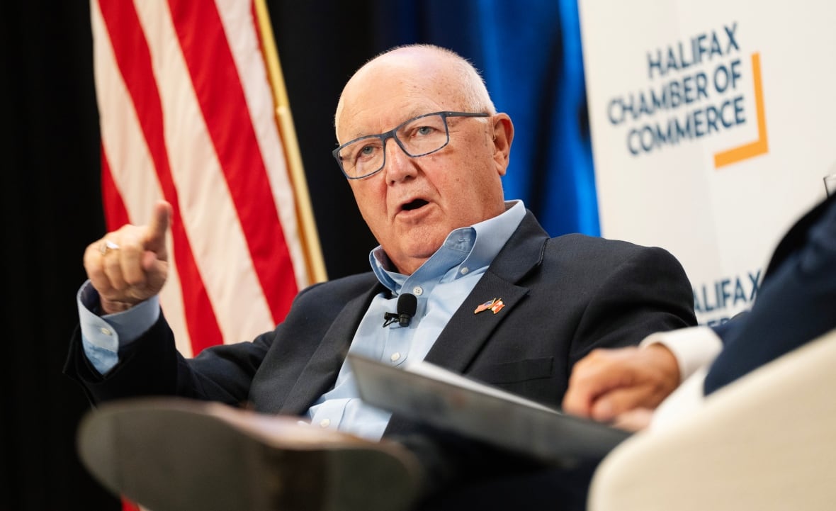 A seated man gestures while speaking. 