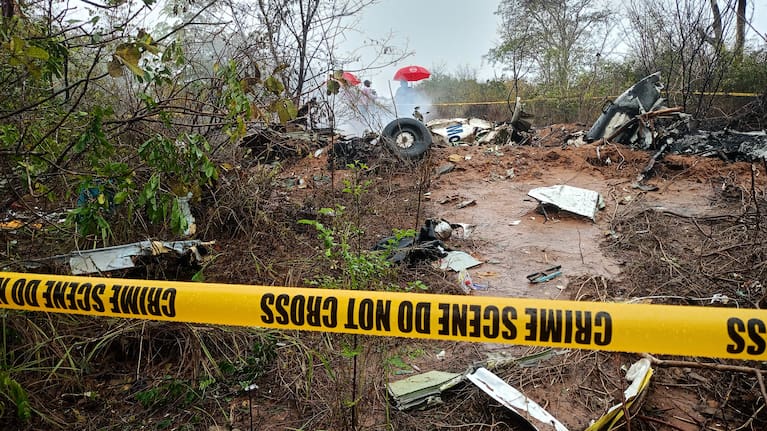 Kenyan officials inspect the scene of a plane crash near Diani, Kenya.