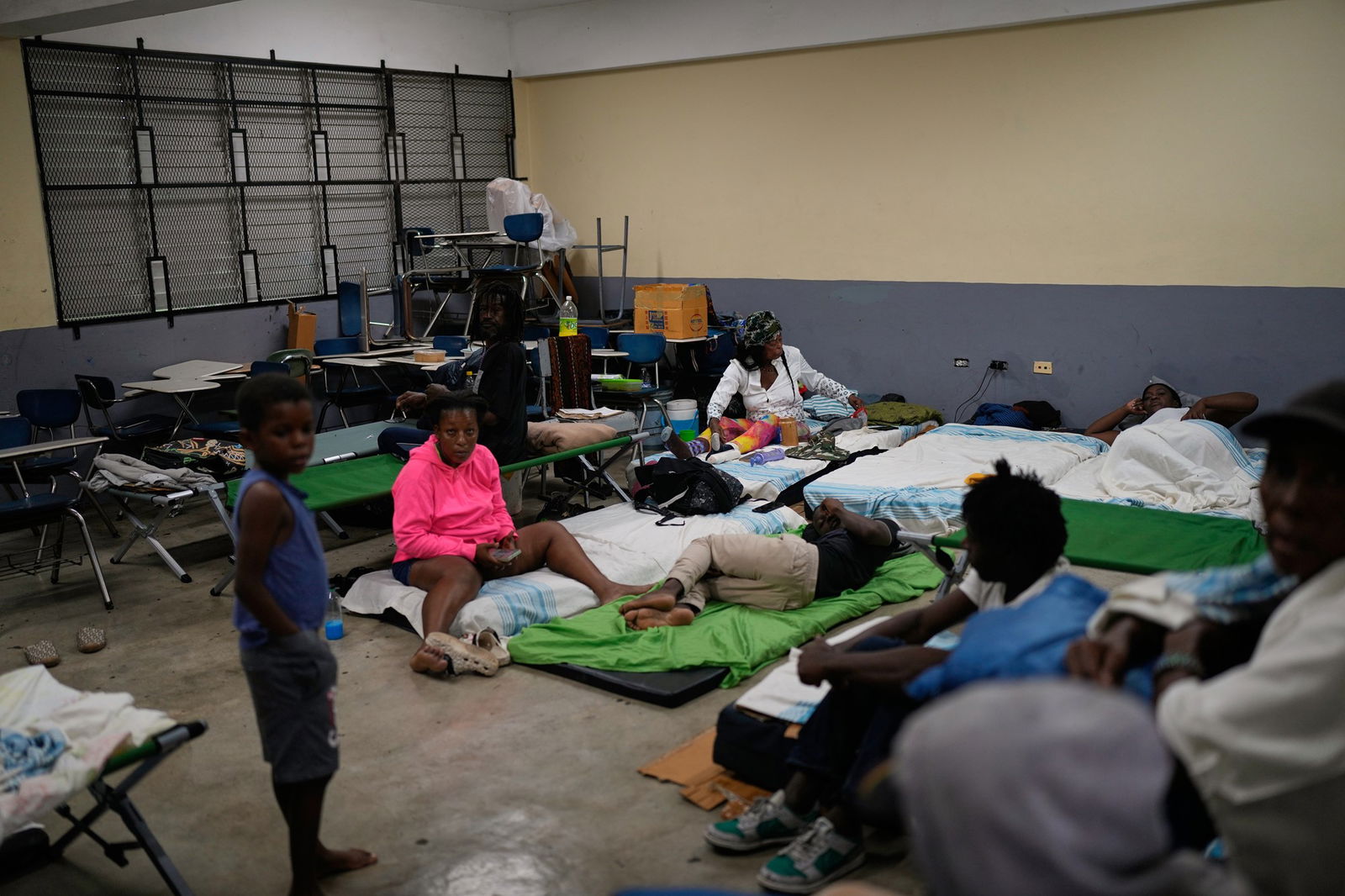 A group of people sheltering inside an evacuation centre.
