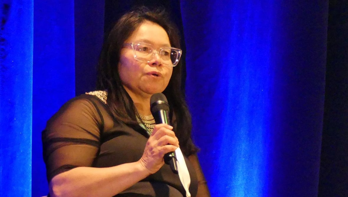 Woman sitting and holding mic talking