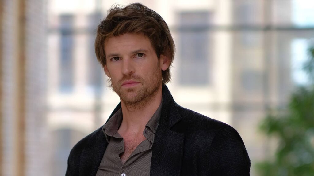 Benjamin Wainwright as Chief Inspector Jules Maigret looks directly at the camera with an intense, intelligent expression on his face.