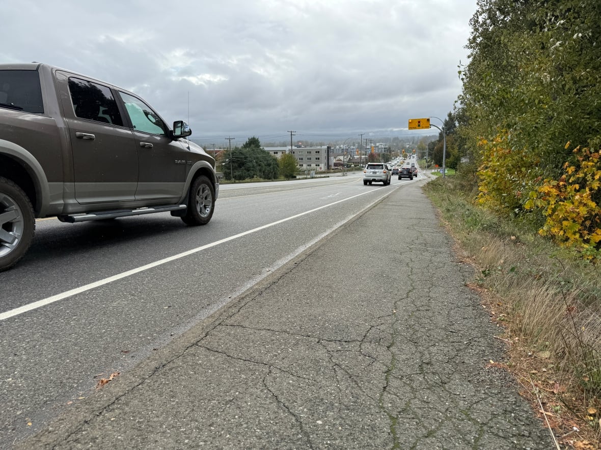 A steep road with cars driving by.