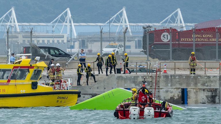 Rescue teams circle the partially submerged green tail of the aircraft. Pic: AP