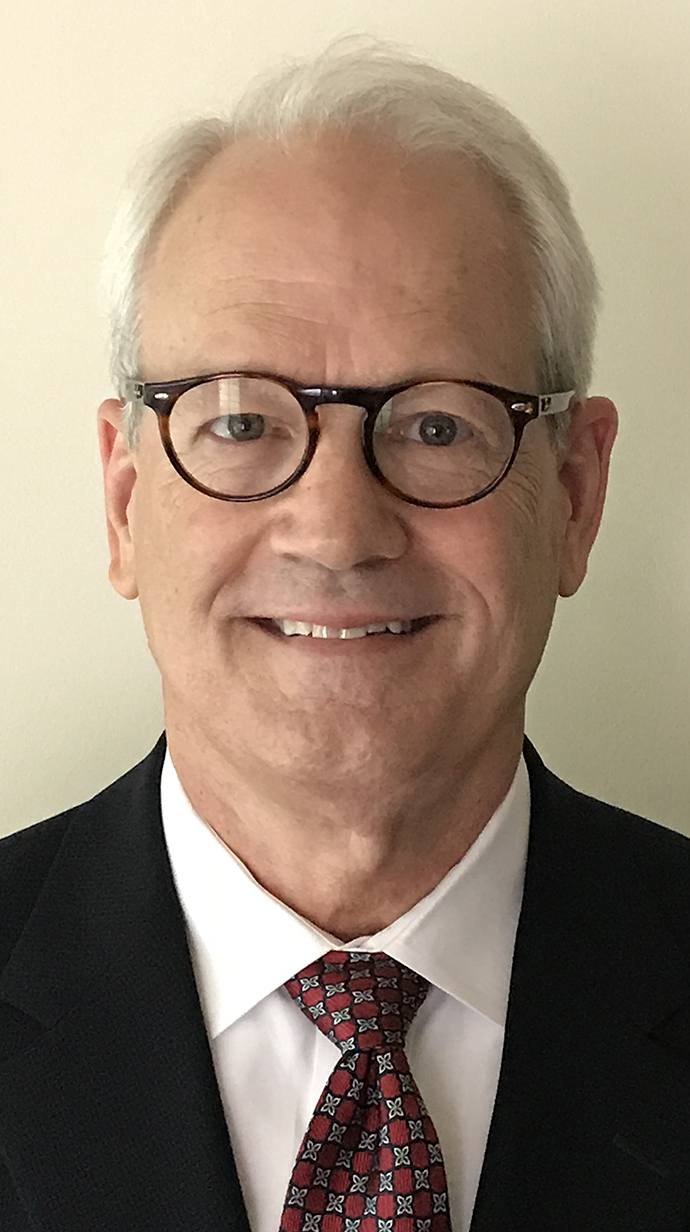 Headshot of a man wearing a dark suit.