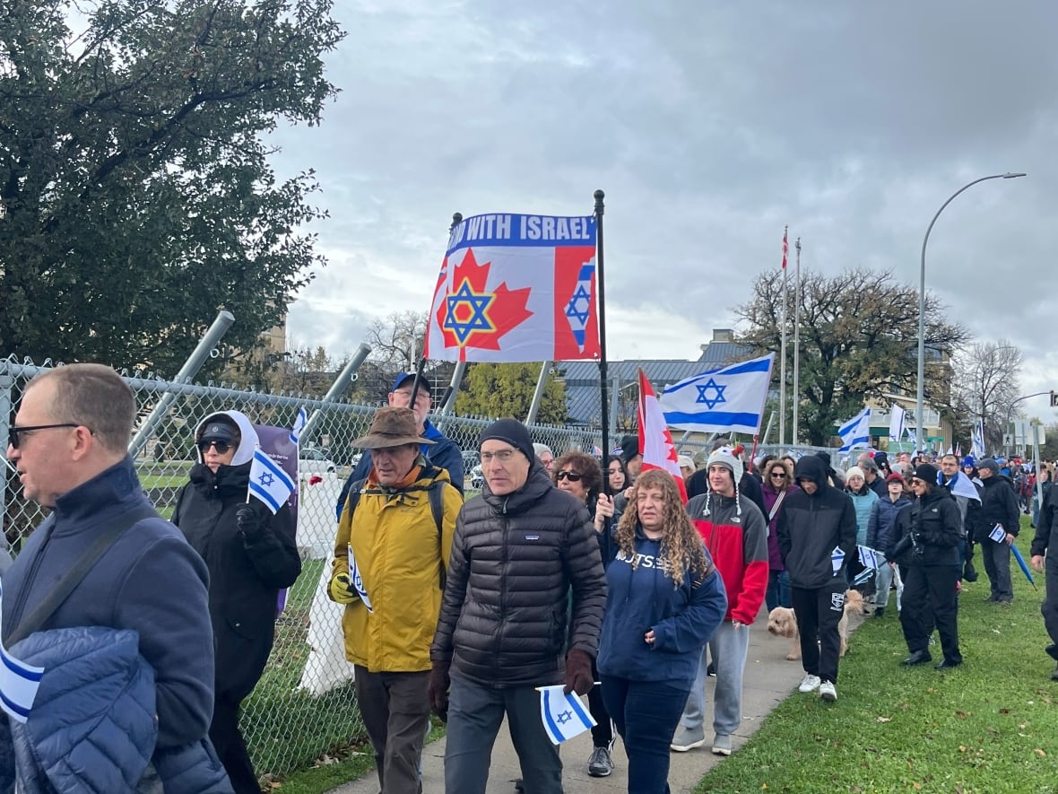 A large group of people is seen walking with many holding up signs 