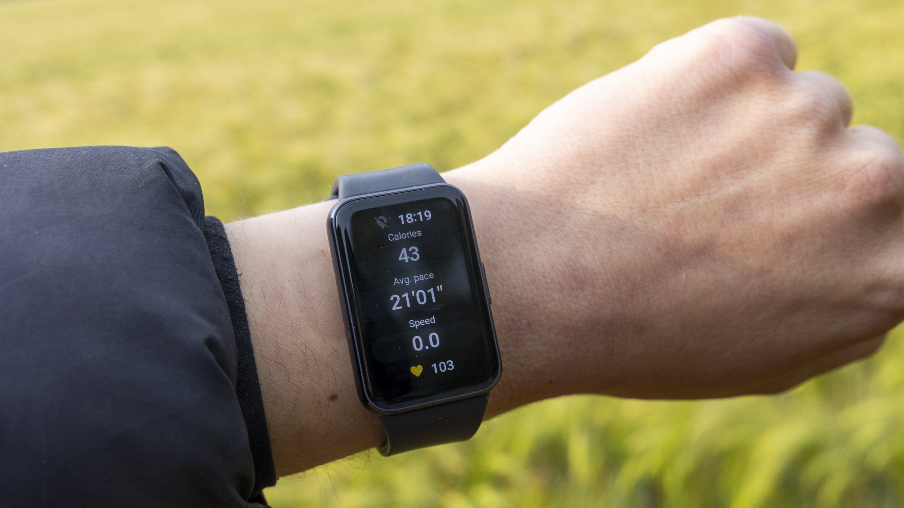 The Samsung Galaxy Fit 3 watch on a female wrist in the sun