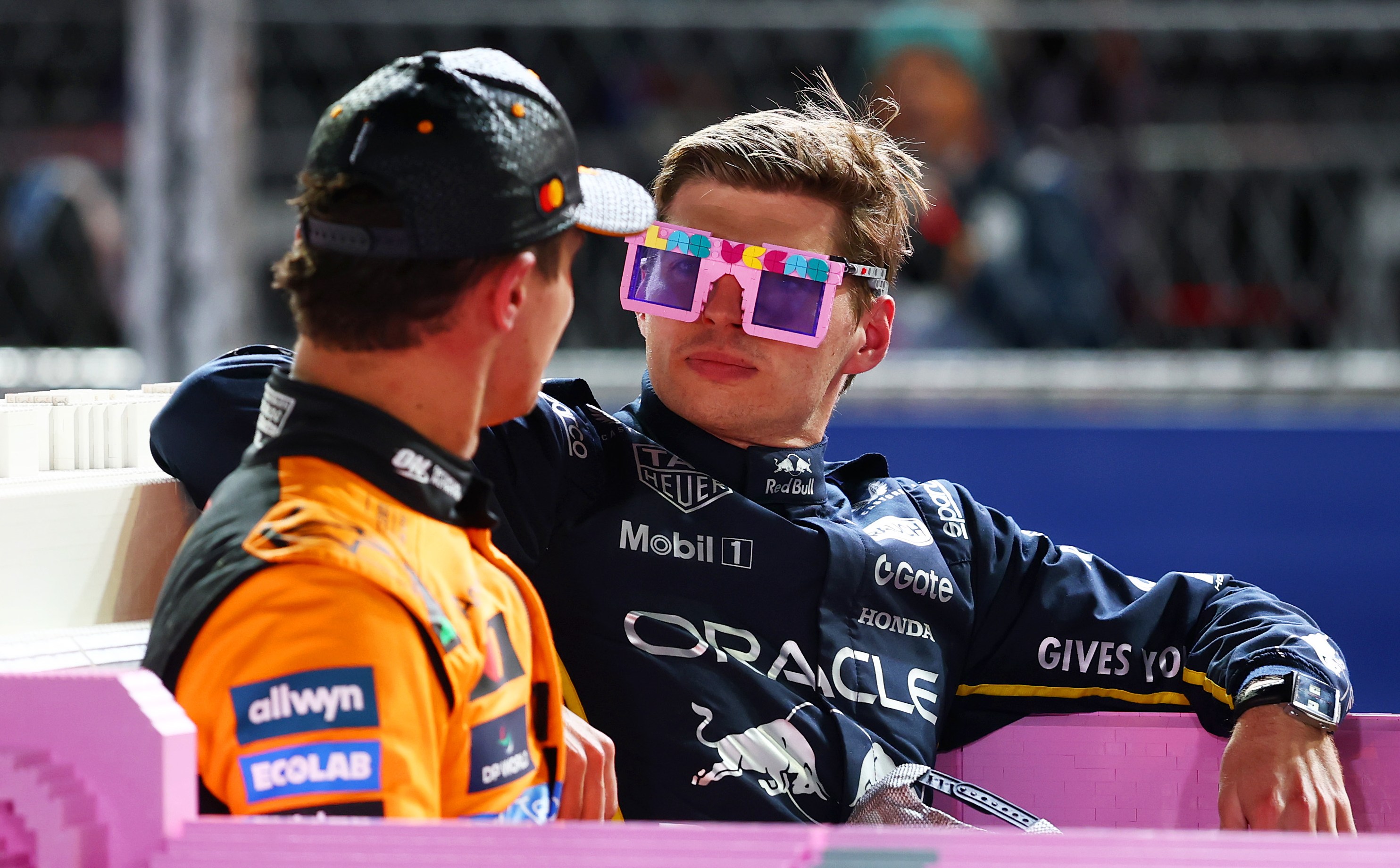 Max Verstappen wearing pink Lego sunglasses and Lando Norris sitting together in a pink Lego Cadillac.