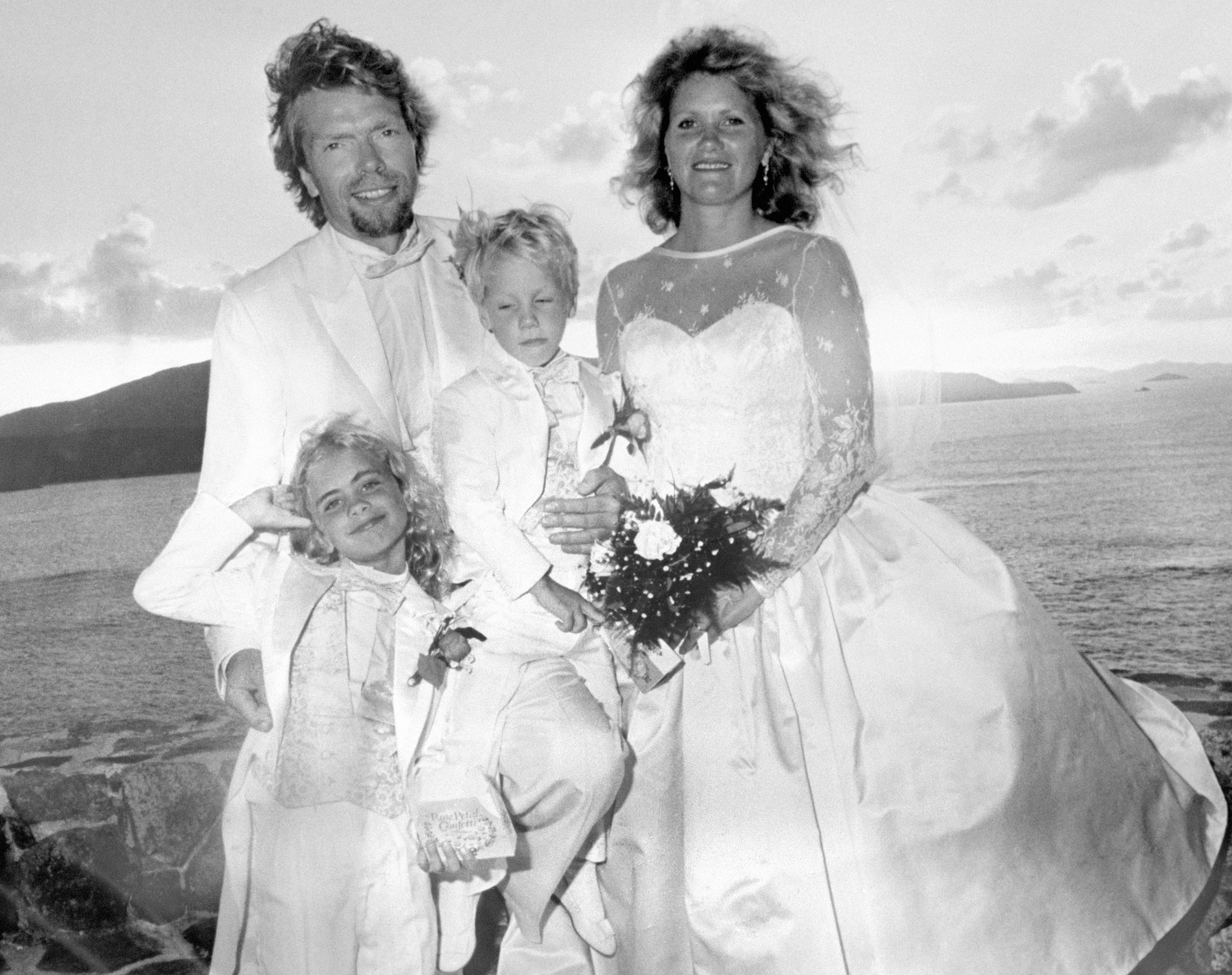 Richard Branson, his wife, and their two young children dressed in wedding attire at their wedding on Necker Island.