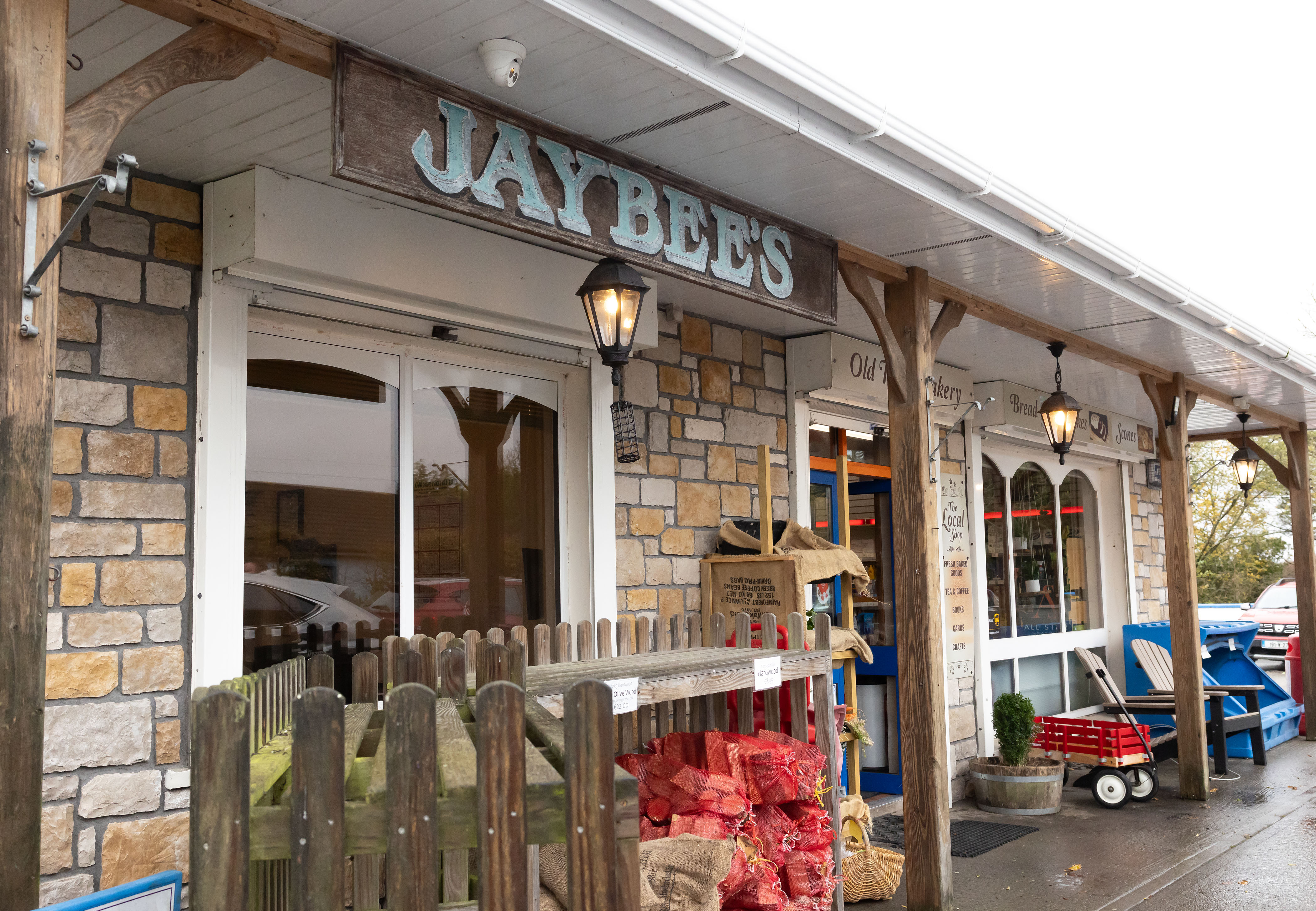 Jaybee's shop with "Old Bakery," "The Local Shop," and various goods like coffee beans, bread, and crafts displayed.