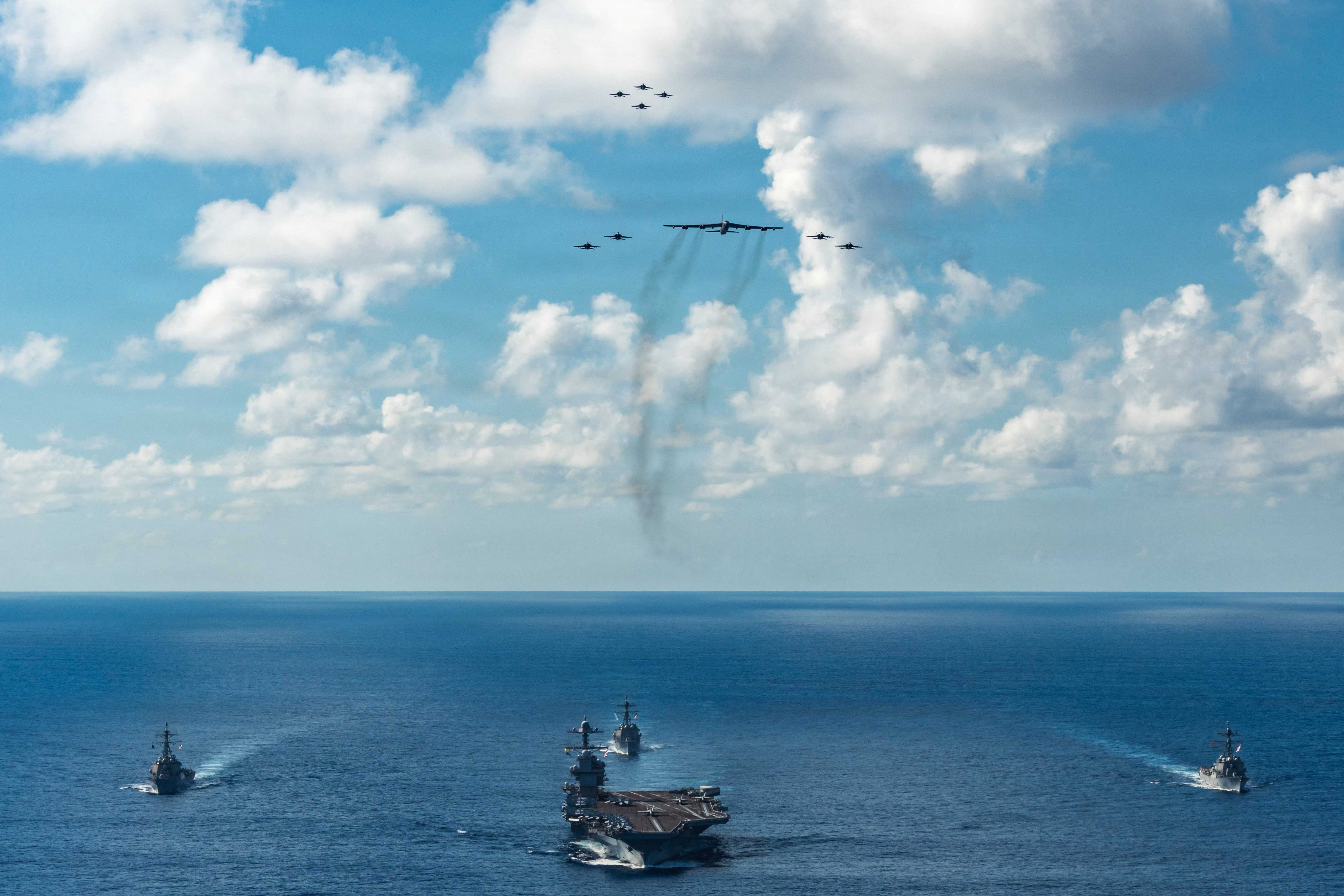 Gerald R. Ford Carrier Strike Group sailing under a B-52 Stratofortress and F/A-18E/F Super Hornets.