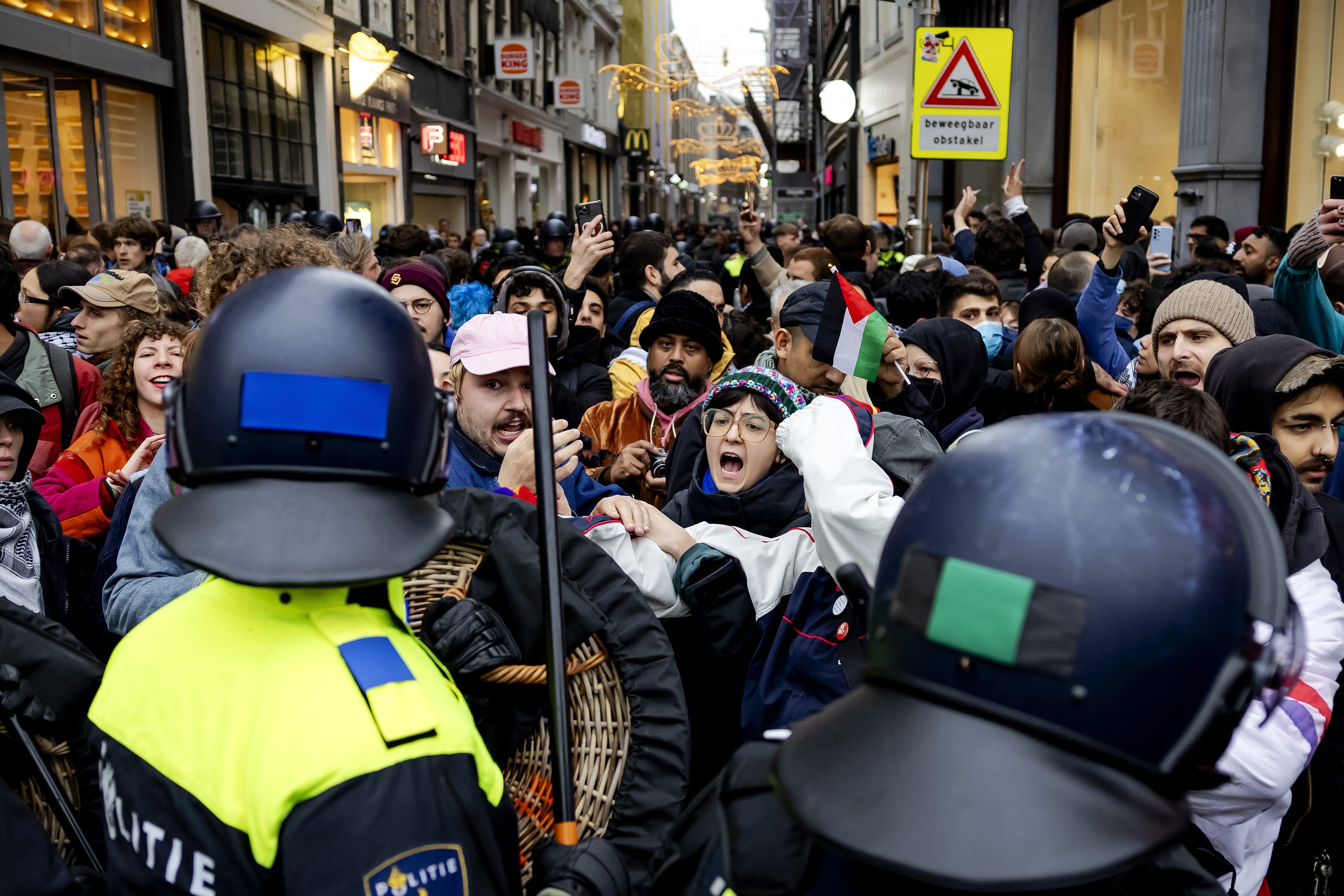 Police officers driving protesters away from Dam Square during a pro-Palestinian protest.