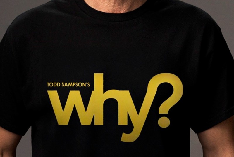Black t-shirt featuring the text "Todd Sampson's why?" in bold yellow letters, highlighting a thought-provoking theme. Perfect for fans of Todd Sampson and his explorations of curiosity and inquiry.
