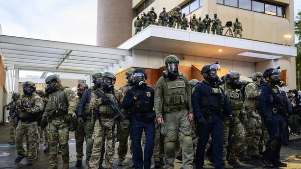 Federal agents stand outside the US Immigration and Customs Enforcement building in Portland, Oregon.