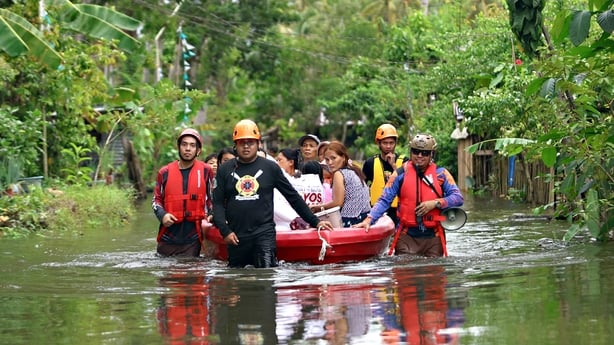 Residents evacuate from their flooded homes due to heavy rain brought by Typhoon Fung-wong
