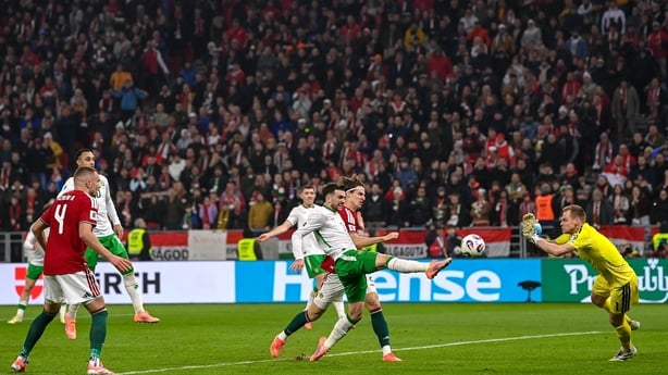 Troy Parrott of Republic of Ireland scores his side's third goal past Hungary goalkeeper Dénes Dibusz during the FIFA World Cup 2026 Group F Qualifier match between Hungary and Republic of Ireland at Puskás Aréna in Budapest