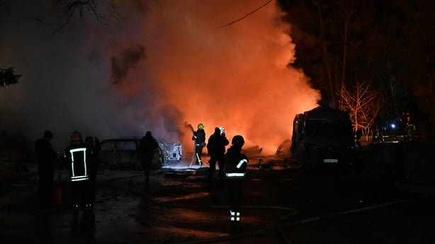 A firefighter uses a water hose to extinguish a fire
