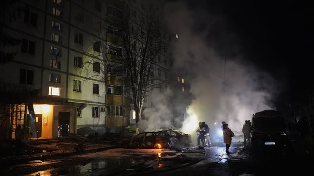 Firefighters extinguish burning cars in the yard of residential building