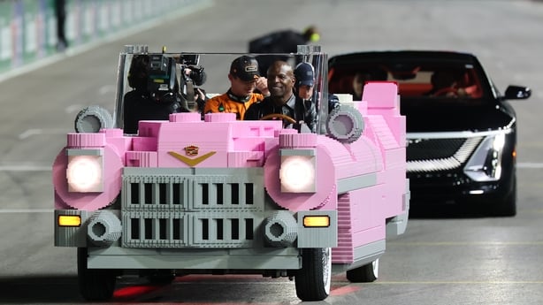 LAS VEGAS, NEVADA - NOVEMBER 22: Terry Crews delivers Race winner Max Verstappen of the Netherlands and Oracle Red Bull Racing Second placed Lando Norris of Great Britain and McLaren and Third placed George Russell of Great Britain and Mercedes AMG Petronas F1 Team to the podium in a Lego pink Cadil