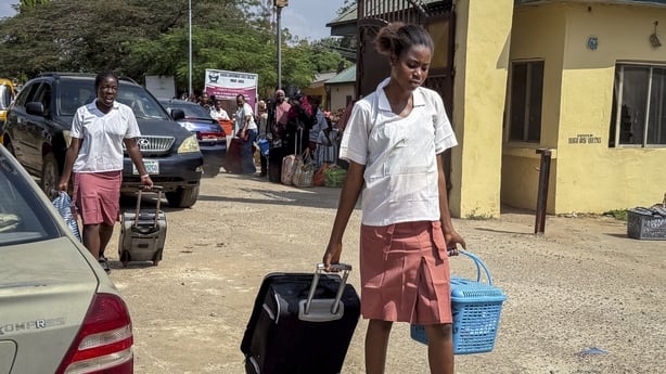 A student pulls her suitcase as she walks out of the Federal Government Girls College in Bwari, on the outskirts of Abuja in Nigeria
