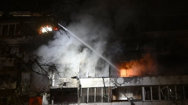 Firefighters put out a fire in a residential building following Russian missiles and drones strikes in Kyiv 