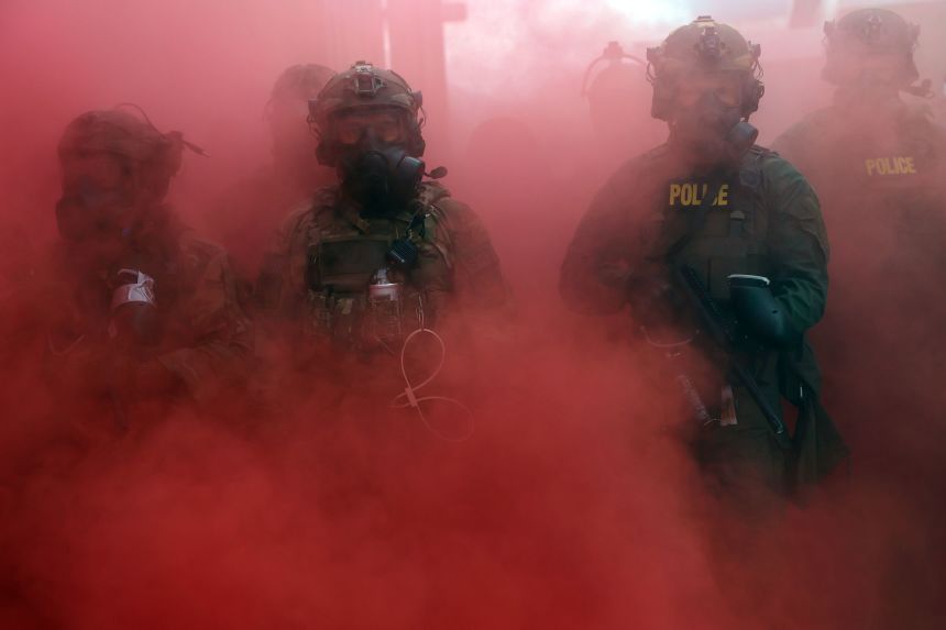 Federal agents hold back protesters while deploying a smoke grenade outside the Immigration and Customs Enforcement facility in Portland on October 4, 2025.