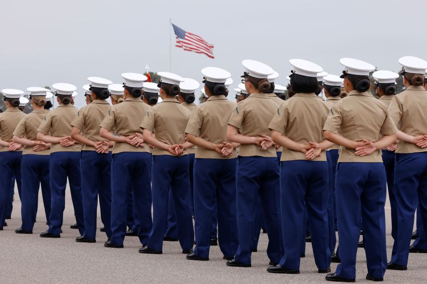 A US flag flies over members of Lima Company's 3rd Recruit Training Battalion, ahead of the ceremony to become the first women to graduate as US Marines, in San Diego, in 2021.