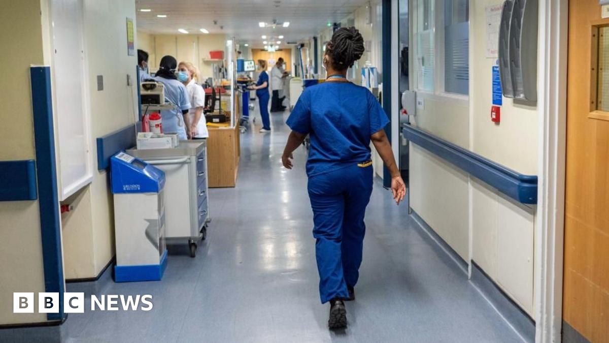 A stock image shows a nurse walking down a hospital corridor