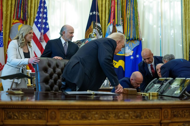 A man faints (2-R) as US President Donald Trump (C) gives remarks in the Oval Office.
